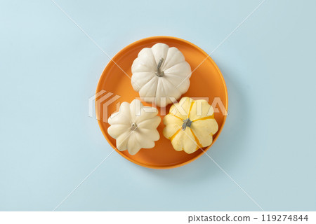 Autumn concept with three pumpkins in seasonal orange plate on blue background. View from above. Thanksgiving Day sale concept. 119274844
