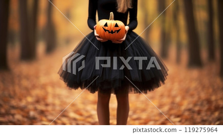 Young Woman in a Black Tutu Skirt Holding a Pumpkin Surrounded by Autumn Forest Scenery Young Woman in a Black Tutu Skirt Holding a Pumpkin Surrounded by Autumn Forest Scenery 119275964