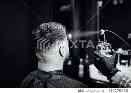 A man getting his hair cut by a barber 119276618