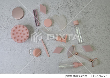 Scattered pink female cosmetic trinkets for skin care and lymphatic drainage face massage with gouache, white background 119276776