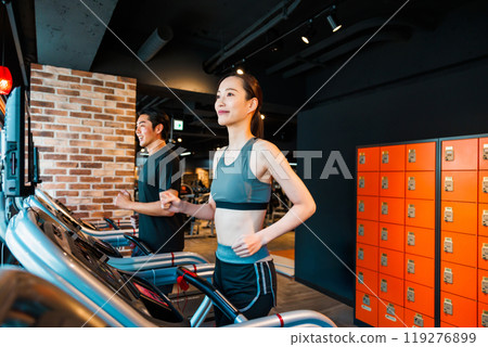 Men and women training on running machines Men and women training on running machines 119276899