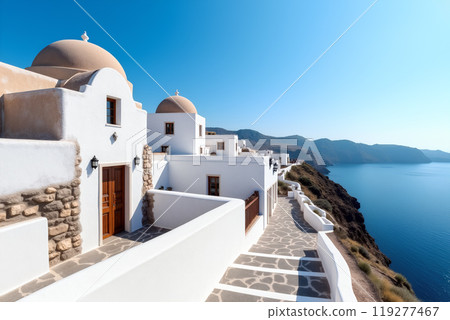 Stunning coastal view of whitewashed buildings along the cliffside in Greece under a clear blue sky 119277467