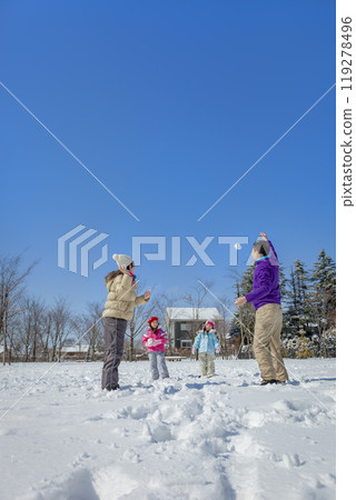 A family of four playing in a snowy park A family of four playing in a snowy park 119278496