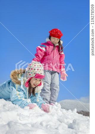 Sisters playing in the snow park 119278509