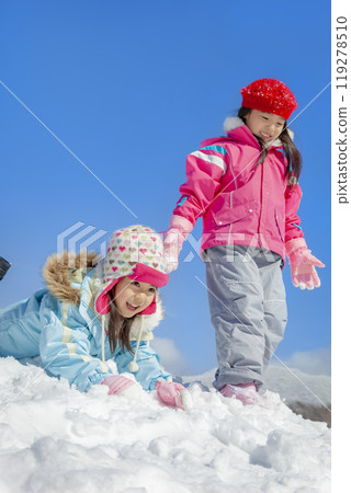 Sisters playing in the snow park 119278510
