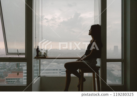 Introvert single woman sitting looking out the view enjoy being alone. 119280325