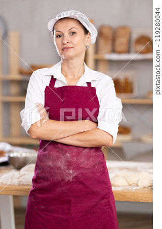 Confident female baker with folded hands 119280944