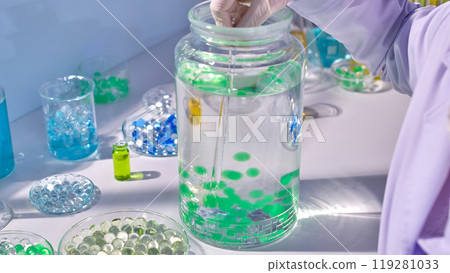 High angle shot photo on white laboratory table top, which displaying a large glass vase of water and hydro balls. Creative template for design, blank space for text High angle shot photo on white laboratory table top, which displaying a large glass vase of water and hydro balls. Creative template for design, blank space for text 119281033