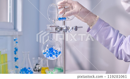 Blue and transaprent hydrogel poured into boiling flask in metal stand in modern laboratory background. Creative template photo for promotional Blue and transaprent hydrogel poured into boiling flask in metal stand in modern laboratory background. Creative template photo for promotional 119281061