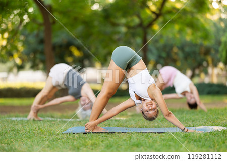 Young woman doing yoga in park 119281112