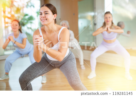 Active young woman practicing aerobic dance in training hall 119281145