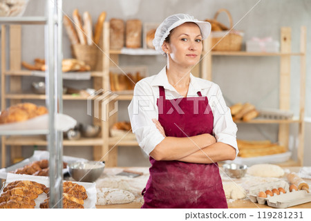 Successful female baker standing with arms crossed in bakery 119281231