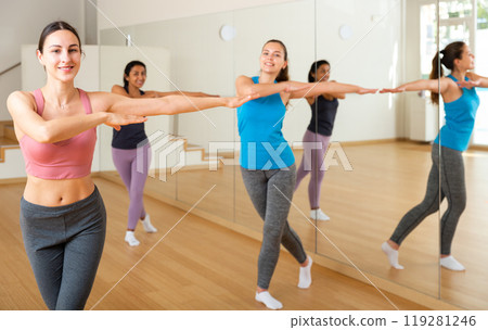 Cheerful girl practicing vigorous jive in group dance class Cheerful girl practicing vigorous jive in group dance class 119281246