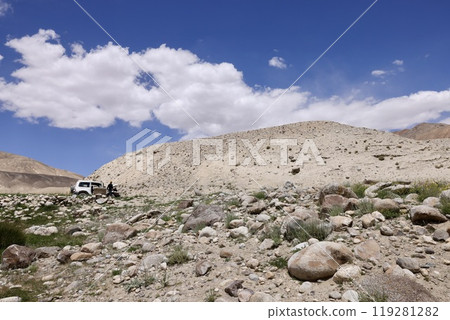 A car broken down on a rough road in the Pamir Mountains A car broken down on a rough road in the Pamir Mountains 119281282