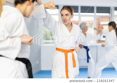 Two women trained to perform basic defensive karate installations and attacking combat techniques Two women trained to perform basic defensive karate installations and attacking combat techniques 119281347