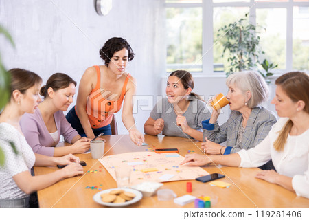 Friendly group of women playing entertaining board game 119281406