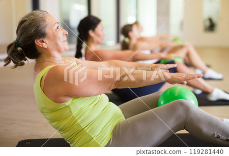 Sporty women doing exercises with pilates balls during group training Sporty women doing exercises with pilates balls during group training 119281440