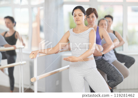 Woman learning passe retire in ballet class for beginners Woman learning passe retire in ballet class for beginners 119281462