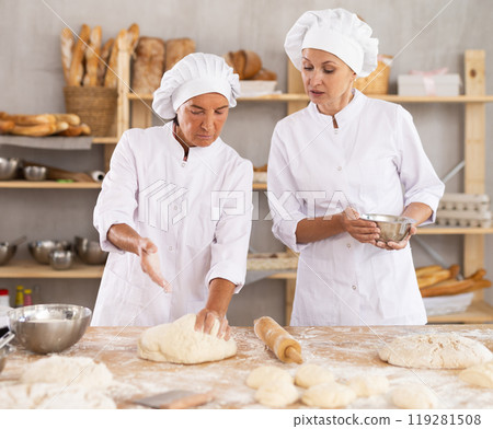 Two women bakers making dough in workshop 119281508