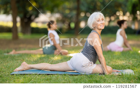 Elderly woman doing yoga in pigeon pose 119281567