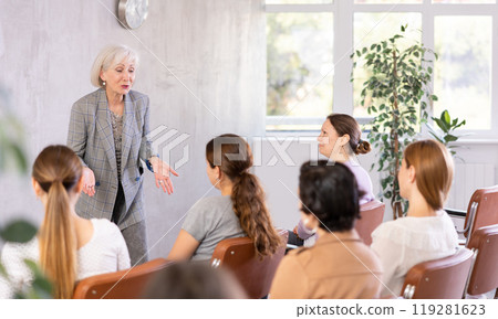Elderly positive woman giving lecture in office 119281623