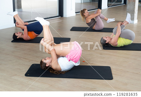 Group of women exercising during pilates class Group of women exercising during pilates class 119281635