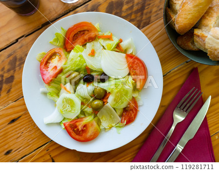 Vegetable salad with lettuce, tomatoes, cucumbers, onions and olives Vegetable salad with lettuce, tomatoes, cucumbers, onions and olives 119281711