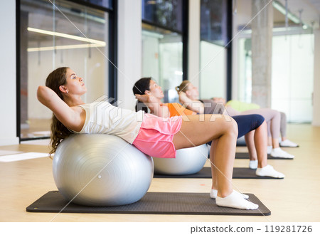 Women doing crunches on stability balls 119281726