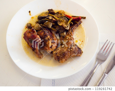 On plate is piece of dietary rabbit meat on bone with braised vegetables 119281742