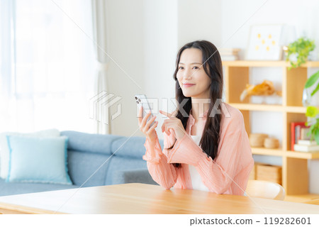 在房間裡操作智能手機的女人 119282601