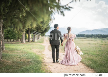 Bride and groom holding hands in a dress in a park (wedding, marriage, romance, bridal, antique) 119283010