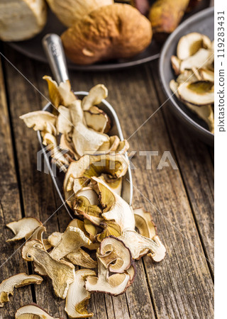Dried porcini mushrooms. Sliced boletus in scoop on wooden table. 119283431