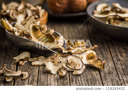 Dried porcini mushrooms. Sliced boletus in scoop on wooden table. 119283432