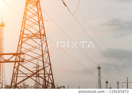 High voltage electric distribution network at sunset. Power transmission lines on supports with ceramic insulators and transformers at large electrical distribution substation 119285872