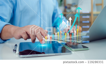 Businessman use tablet showing a growing virtual hologram of analytics dashboard with charts, Stock market, Business growth, Progress or success concept, Invest in trading, Finance, Sales, Marketing. 119286331