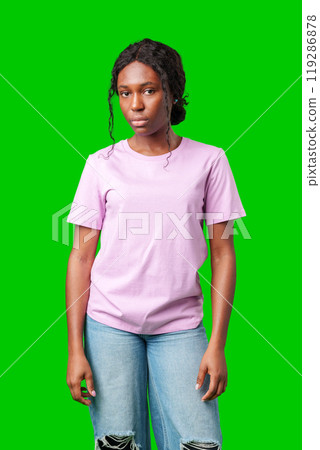Young woman with an expression of contemplation poses against a bright green background Young woman with an expression of contemplation poses against a bright green background 119286878