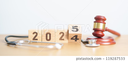 2024 end year to Happy New Year 2025 with Stethoscope of doctor and Judges gavel on table. health care Law, Insurance, Wellness, medical Tax, cost, Auction and Bidding concepts 119287533