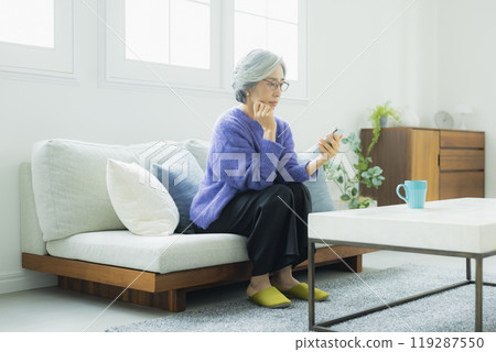 一位身穿針織品的高級女性在客廳放鬆 119287550