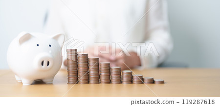Money Saving for Future Plan, Retirement fund, Pension, Investment, Wealth Business and Financial concepts. hand putting coin into piggy bank on table, Money Counting and stack arrangement for deposit 119287618