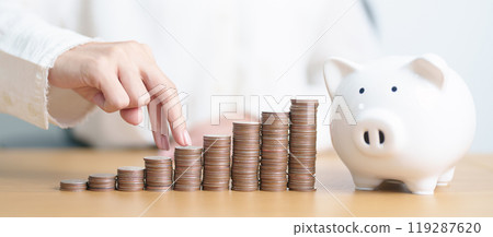 Money Saving for Future Plan, Retirement fund, Pension, Investment, Wealth, Salary and Financial concepts. hand step up coin with piggy bank on table, Money Counting and stack arrangement for Growth 119287620