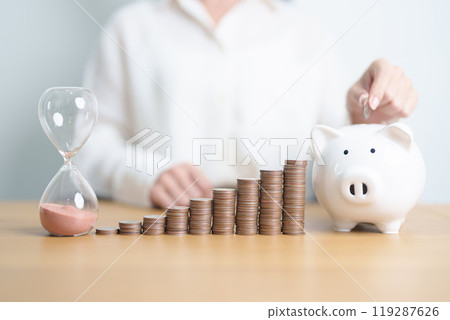 Money Saving for Future Plan, Retirement fund, Pension, Investment, Wealth Business and Financial concepts. coins stack, piggy bank with sandglass on table 119287626