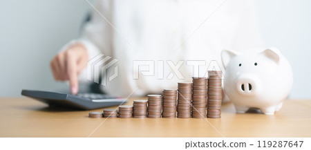Money Saving for Future Plan, Retirement fund, Pension, Investment, Wealth Business and Financial concepts. Woman Counting and calculate money with coins stack with piggy bank for deposit 119287647