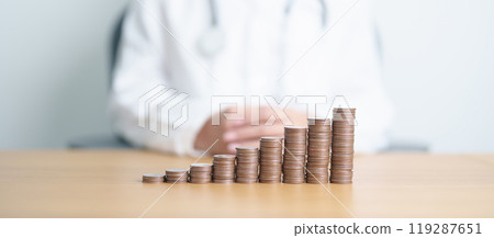 Money Saving, Health Insurance, Medical, Donation and Financial concepts. Doctor with coins stack on table. Money stack Counting arrangement for deposit and Healthcare cost 119287651