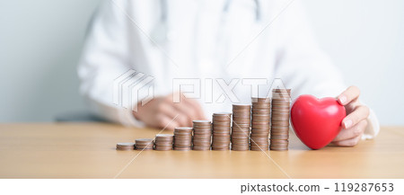 Money Saving, Health Insurance, Medical, Donation and Financial concepts. Doctor with coins stack and Heart on table. Money stack Counting arrangement for deposit and Healthcare cost 119287653