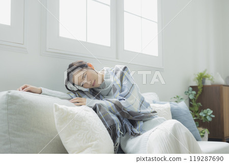 A woman feeling unwell in her living room in winter A woman feeling unwell in her living room in winter 119287690