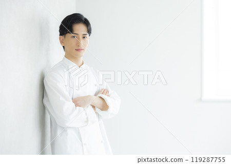 一個穿著廚師外套的年輕人 一個穿著廚師外套的年輕人 119287755