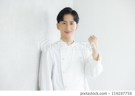 A young man wearing a chef's coat 119287758