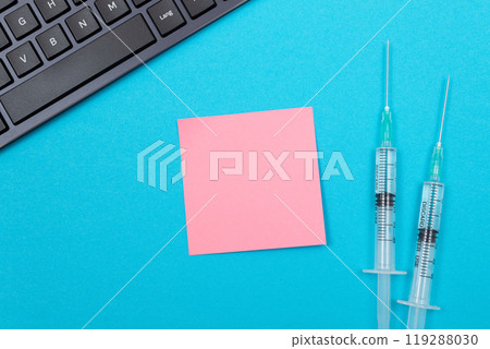 Vaccination or Revaccination Concept - Two Medical Syringe on Blue Table Vaccination or Revaccination Concept - Two Medical Syringe on Blue Table 119288030