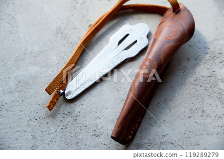Jew's harp in a brown genuine leather case on a gray background. Sound therapy. 119289279