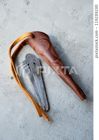 Jew's harp in a brown genuine leather case on a gray background. Sound therapy. 119289280